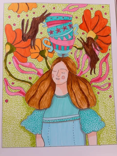 Niña de vestido celeste con el pelo largo entre flores naranjas
